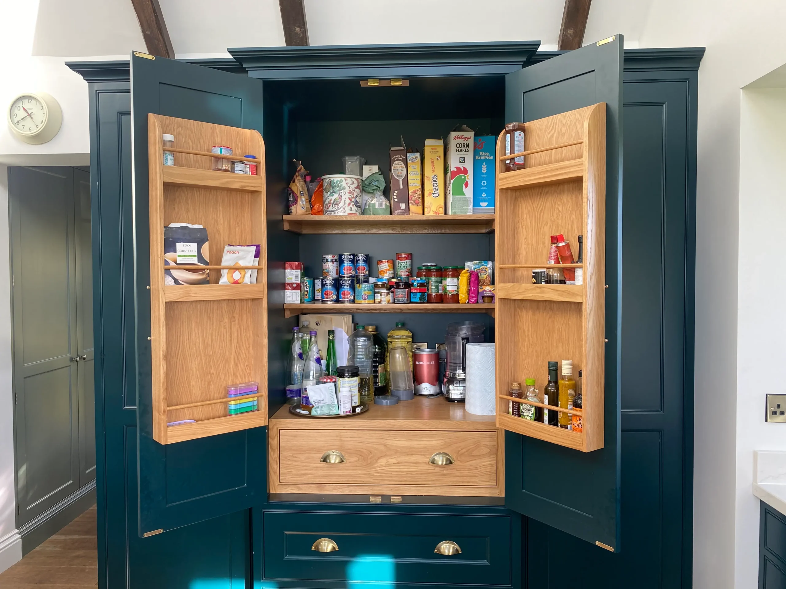 Exceptional bespoke joinery kitchen pantry cupboard in a dark green colour.
