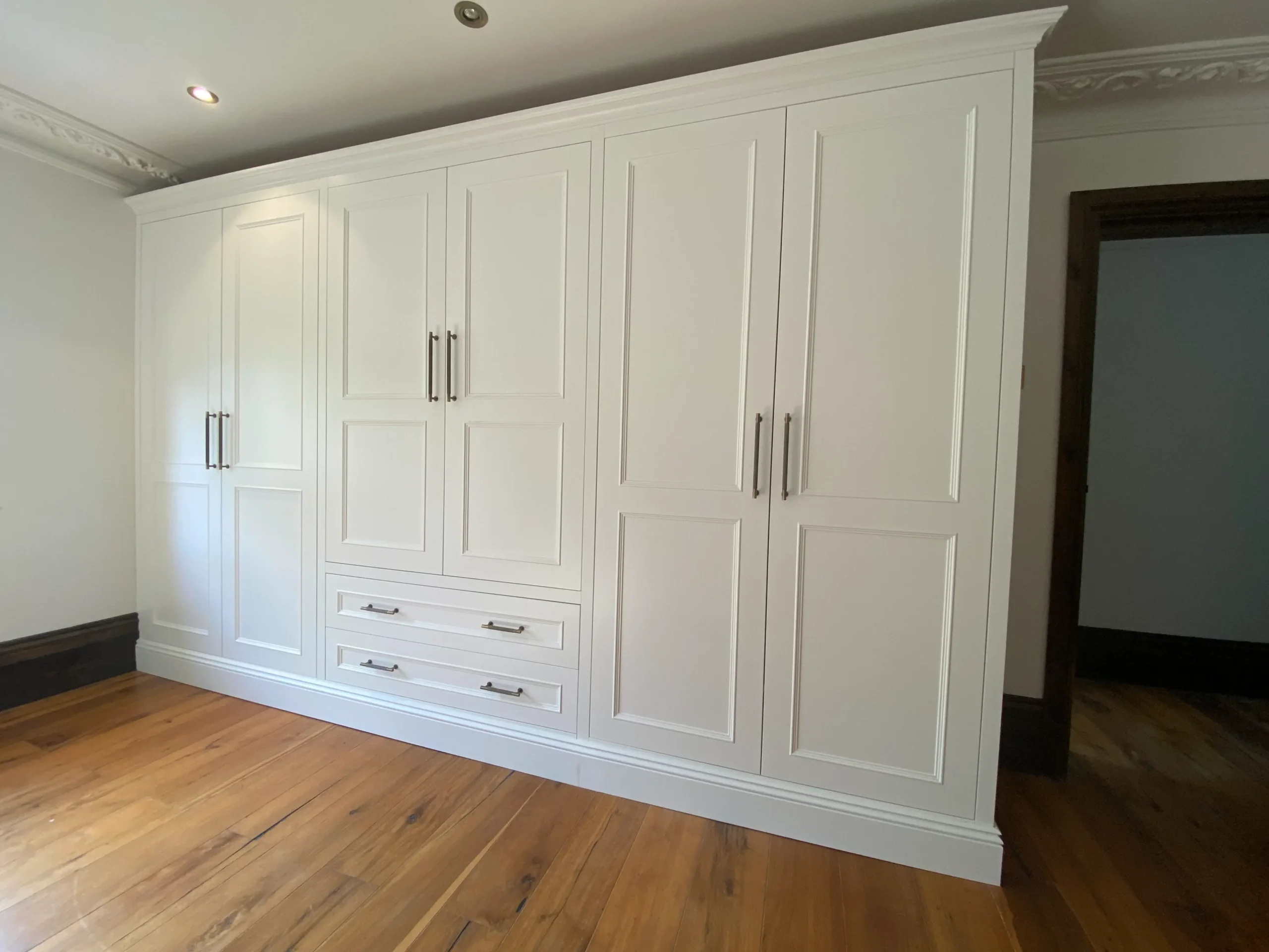 A white wardrobe set bespoke joinery work by Tru English.
