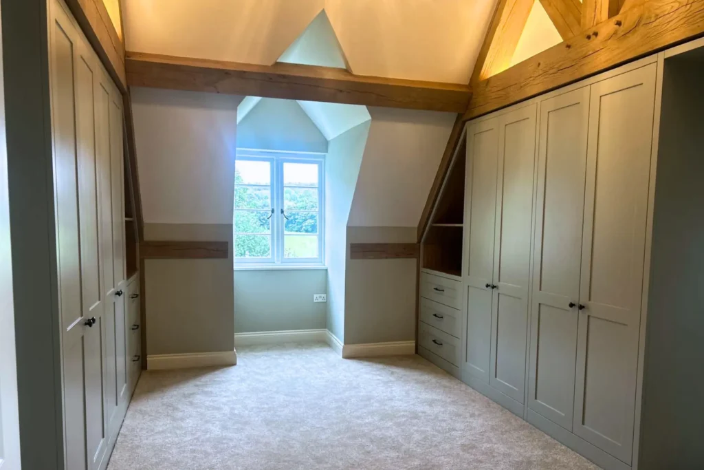 Luxury bespoke joinery sage green walk-in wardrobe units.