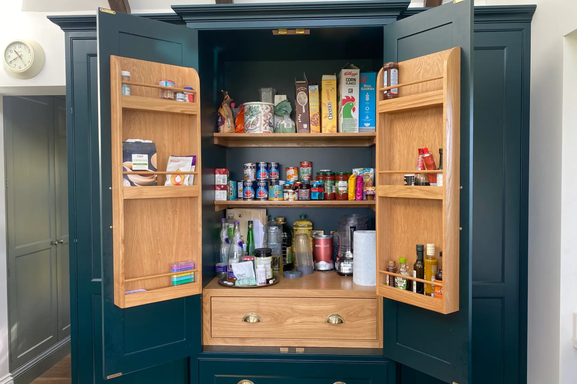 Teal green larder cupboard with internal wooden shelving for condiments