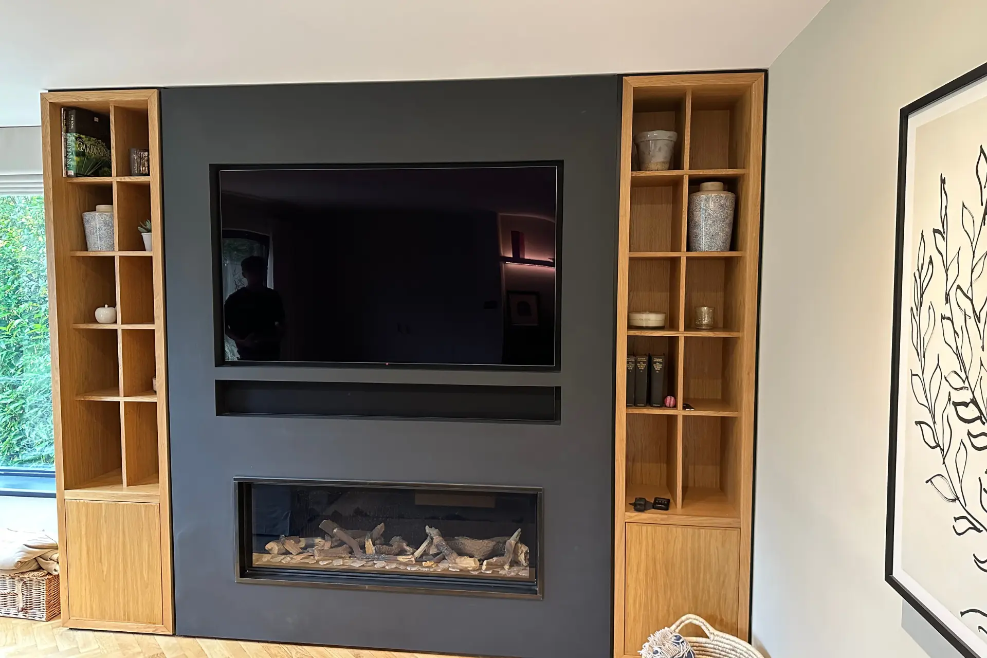 bespoke oak shelving incorporating a television and fire