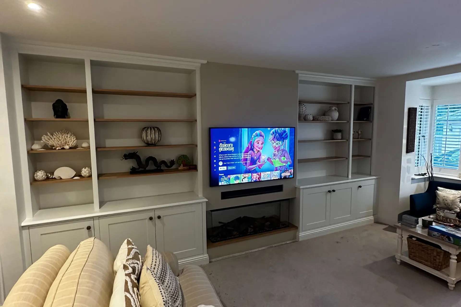 built in white bespoke shelving in a living room