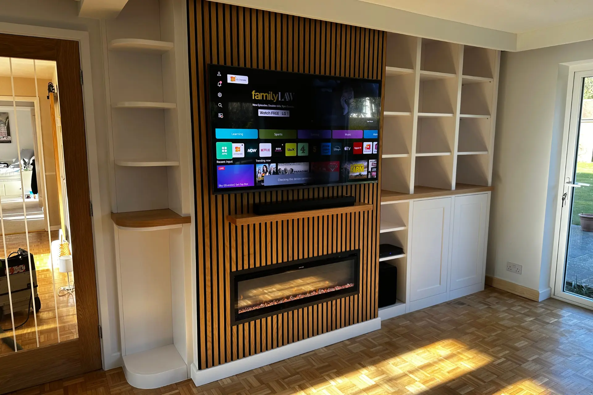 Cinema wall with wood acoustic panels and white shelving
