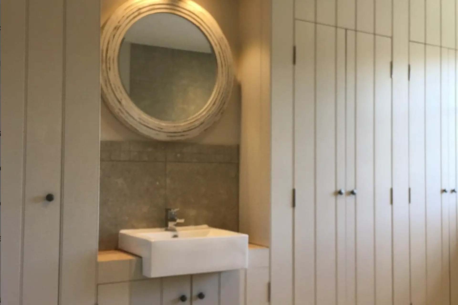 mirror set in floor to ceiling light wood cabinets