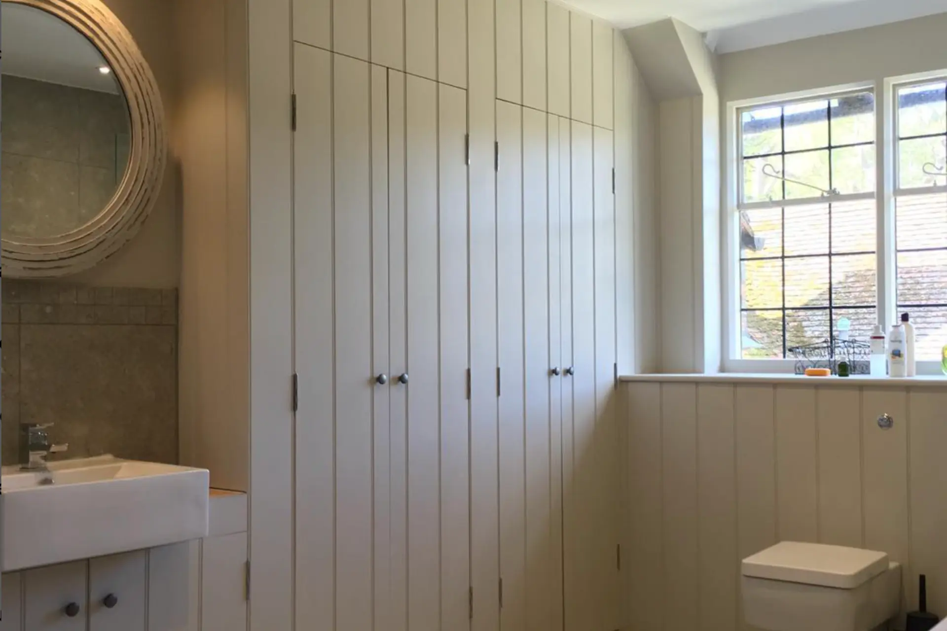 light wood floor to ceiling cupboards in a bathroom