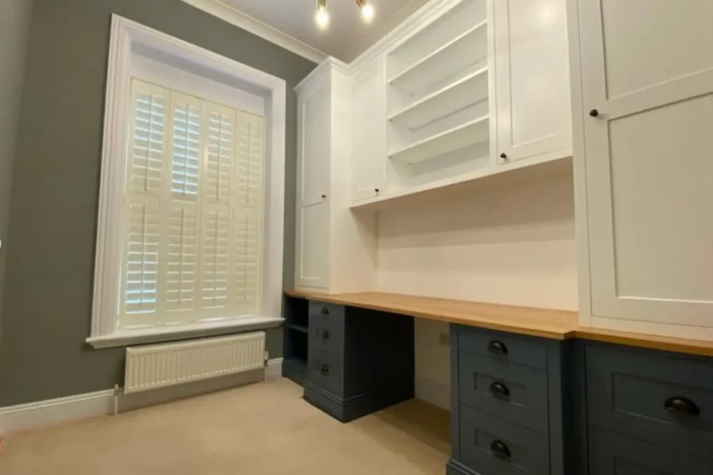 bespoke home office furniture, dark blue desk, white cupboards and shelves, oak desktop