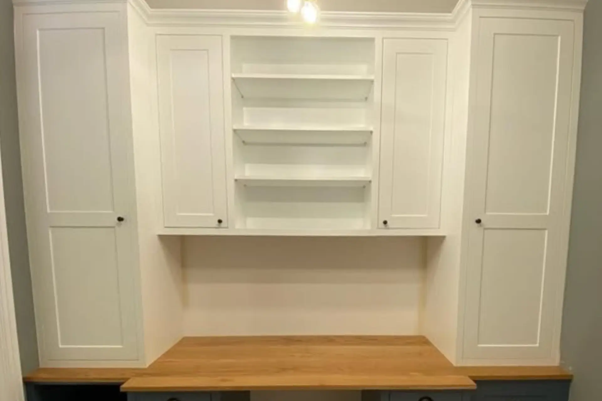 white wood fitted office storage with an oak desk top