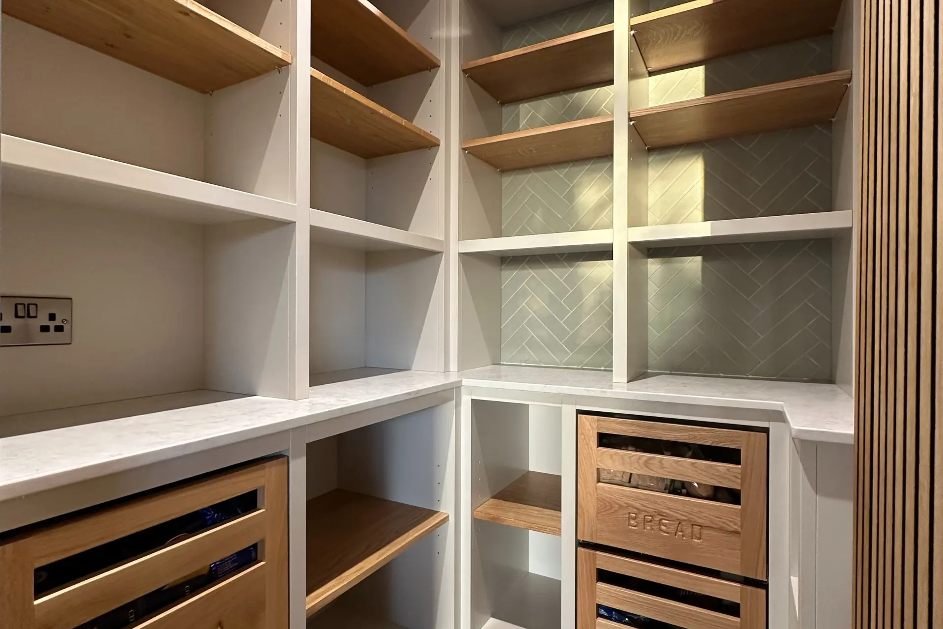 walk-in pantry with white open shelving and wood deep drawers